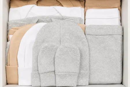 Cajita de regalo unisex para recién nacido con prendas en tonos neutros y conejito de apego